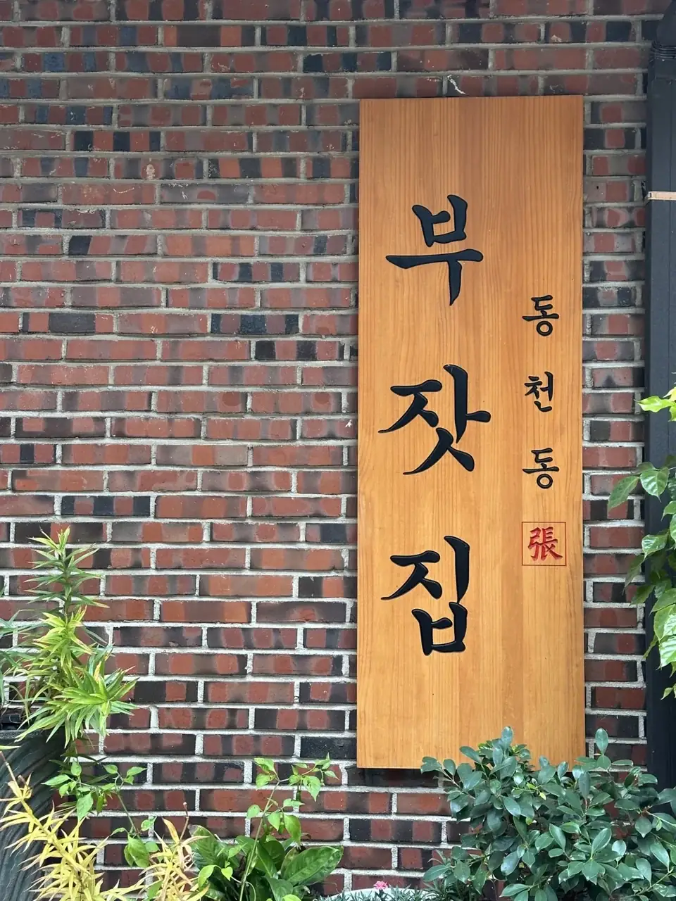 벽돌 벽에 걸린 동천동 부잣집 나무 간판
