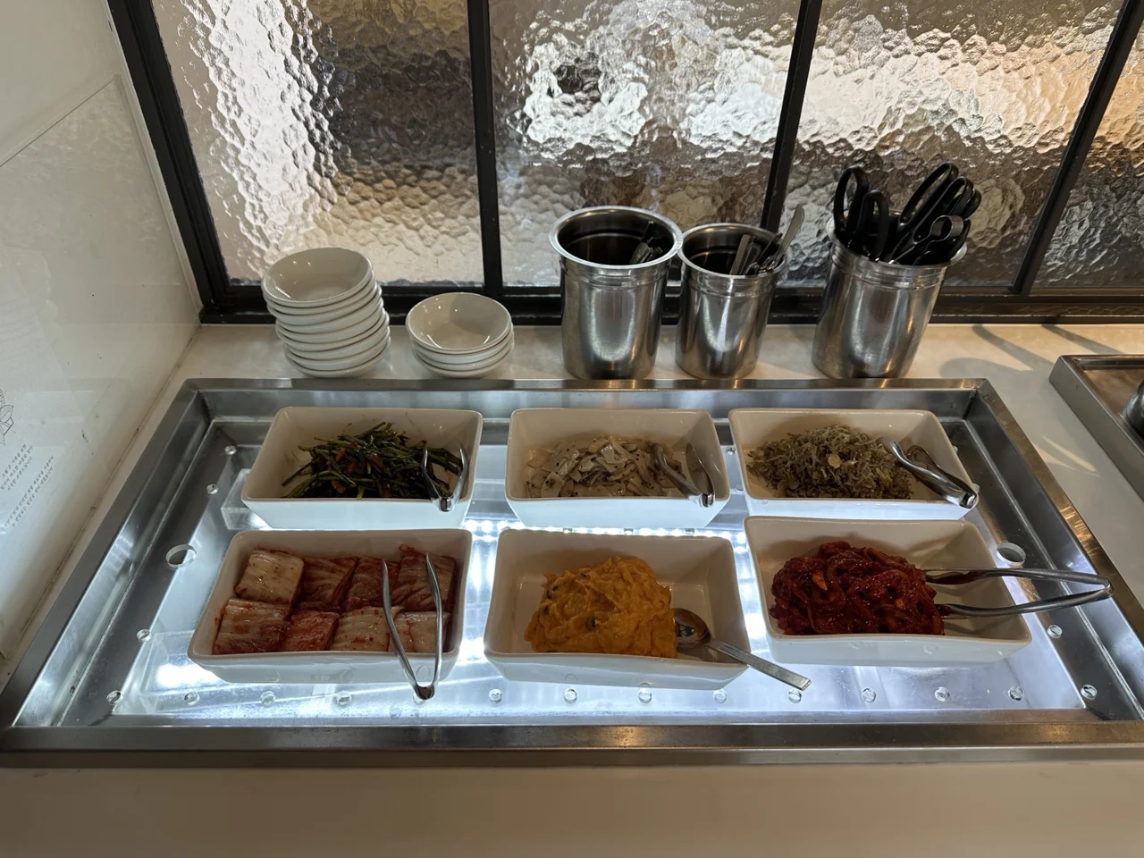 반찬 여섯 종류와 접시가 놓인 셀프바