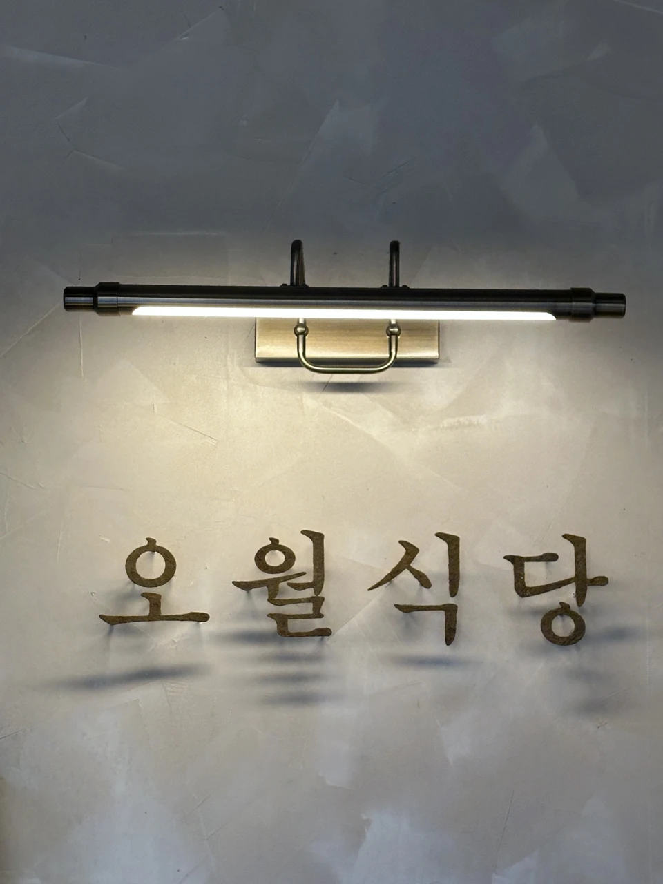 조명 아래 오월식당 글자 간판